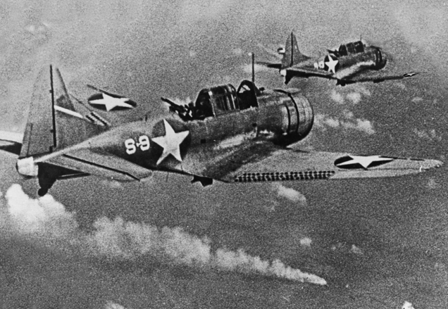 SBD-3 Dauntless dive bombers of scouting squadron VS-8 from the aircraft carrier USS Hornet (CV-8) approach the burning Japanese heavy cruiser Mikuma during the Battle of Midway on June 6, 1942 (US Navy)